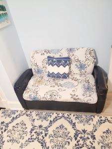 Room in Apartment - Blue Room in Delaware في دوفر: أريكة عليها وسادة في الغرفة