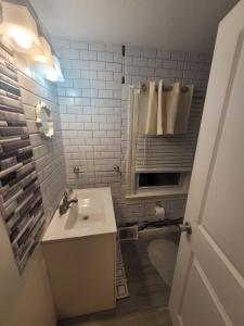 a white bathroom with a sink and a mirror at Room in Apartment - Blue Room in Delaware in Dover