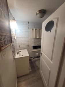 a bathroom with a sink and a toilet and a door at Room in Apartment - Blue Room in Delaware in Dover