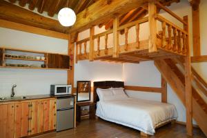 a bedroom with a loft bed and a kitchen with a sink at Samlockhon Hanokstay in Jeonju