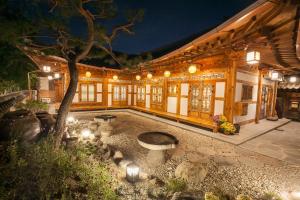 un edificio con un patio con un árbol y luces en Samlockhon Hanokstay en Jeonju