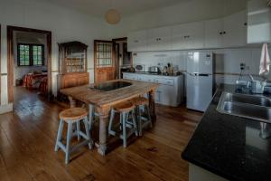 una cocina con mesa de madera y taburetes. en The 100 Year Old House, en Nanyuki