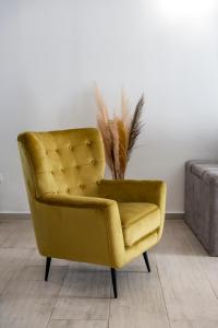 żółte krzesło siedzące w pokoju obok kanapy w obiekcie Modern Apartment Paula-with private pool w mieście Čibača