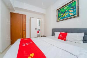 sypialnia z łóżkiem z czerwonym kocem w obiekcie RedLiving Apartemen Green Lake View Cimanggis - WIN Property w mieście Depok