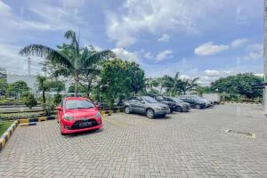 rząd zaparkowanych samochodów na parkingu w obiekcie RedLiving Apartemen Green Lake View Cimanggis - WIN Property w mieście Depok
