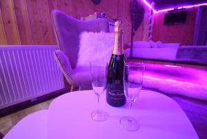 - une bouteille de champagne et deux verres sur une table dans l'établissement Aux 67 nuances - Spa, à Châtenois