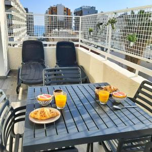 a blue table with food and drinks on a balcony at Sea Breeze Central, 2bed in Limassol