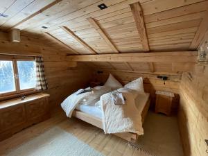 um quarto com uma cama num chalé de madeira em Alpenchalet Piz Hüsli em Tschagguns