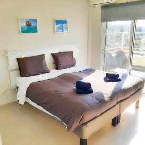 a bed with two blue towels sitting on top of it at Sea Breeze Central, 2bed in Limassol