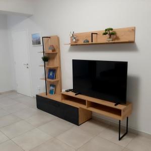 a flat screen tv sitting on a wooden entertainment center at Sea Breeze Central, 2bed in Limassol