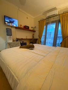 1 cama blanca grande en una habitación con ventana en Kost Studio 62 en Depok