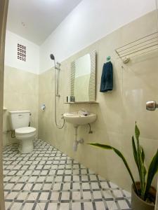 a bathroom with a sink and a toilet and a mirror at Kost Studio 62 in Depok