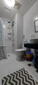 La salle de bains est pourvue de toilettes, d'une douche et d'un tapis. dans l'établissement Rochester Condo, à Manille
