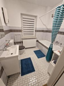 La salle de bains est pourvue d'un lavabo, de toilettes et d'une baignoire. dans l'établissement Ferienwohnung am Grambker See, à Brême