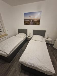 two beds in a room with two tables at Ferienwohnung am Grambker See in Bremen
