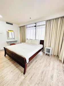 een slaapkamer met een groot bed en een groot raam bij KL Cozy Suite Times Square in Kuala Lumpur