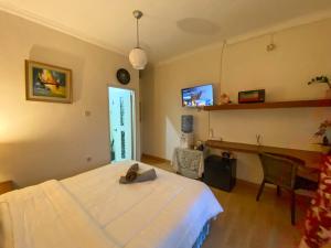 a bedroom with a bed and a desk and a tv at Studio 62 in Depok