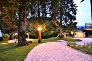 a brick walkway in a park with trees and lights at Vila Ključe Apartments in Bled