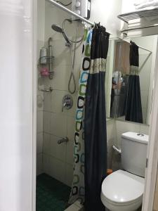 a bathroom with a shower curtain and a toilet at smdc residences tagaytay tower 1 condo unit in Tagaytay +5 photos