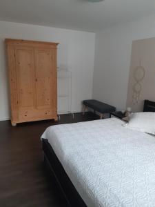 een slaapkamer met een bed en een houten kast bij Appartement FreiRaum in Sankt Martin am Tennengebirge