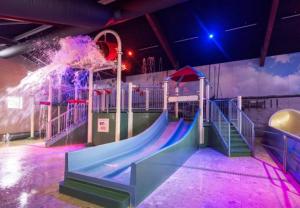 a playground with a slide in a room at Stacaravan op 5 Sterren Vakantiepark De Kuilart Friesland aan het Meer met Zwembad 5P 237 in Koudum