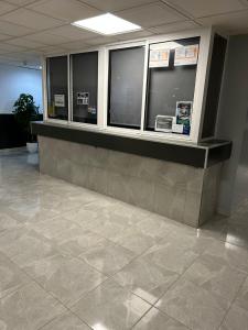 a lobby with a counter with windows and a tile floor at La Pineda playa in La Pineda