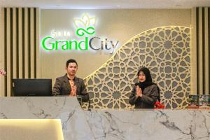 two people standing at a table in front of a sign at Solo Grand City in Lawean