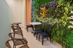 a wall with chairs and a table in a room at Solo Grand City in Lawean