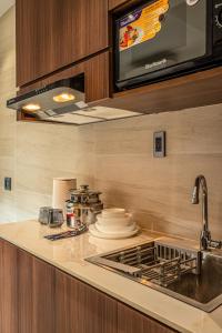 a kitchen with a sink and a stove top oven at Stockholm Apartment in Ho Chi Minh City