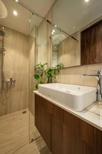 a bathroom with a white sink and a shower at Stockholm Apartment in Ho Chi Minh City