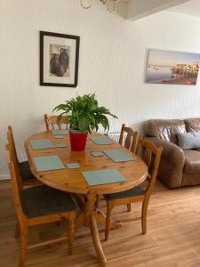 a wooden table with a potted plant on it in a living room at Cosy coastal home - 5 mins walk from the beach in Horton