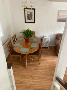 una mesa de comedor con sillas y una planta en Cosy coastal home - 5 mins walk from the beach en Horton