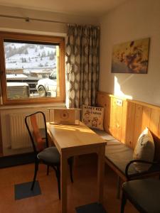 een kamer met een tafel en stoelen en een raam bij Haus BIENENHOAMAT in Nauders