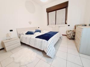 biała sypialnia z łóżkiem i krzesłem w obiekcie San Siro House w Mediolanie