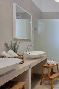 een badkamer met een wastafel en een spiegel bij Little Bird Lesvos in Petra