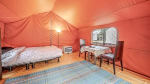 a bedroom with a bed and a desk in a tent at Club Lespia Gapyeong 1st Branch in Gapyeong