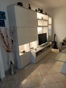 een woonkamer met een wit entertainmentcentrum met een televisie bij La casa dei ricordi in Acqualagna