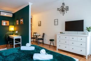 a bedroom with a tv and a bed with two pillows at Romantic Studio secret garden in Budapest