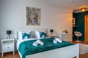 a bedroom with a large bed with a green blanket at Romantic Studio secret garden in Budapest