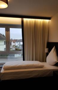 een slaapkamer met een bed en een groot raam bij ING Hotel by WMM Hotels in Ingolstadt