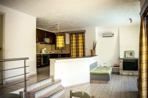 a living room with a kitchen with a counter top at Nine Muses Villas - Clio Terpischori in Hersonissos