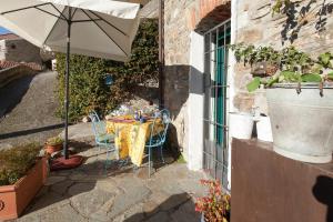 a table with an umbrella next to a building at Chezcatherine in Sarzana