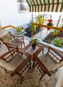 a patio with a table and chairs and a balcony at Angel Mezonet in Amaliás