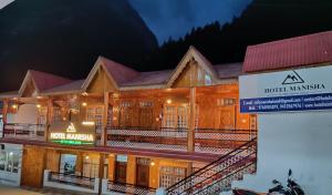 a hotel with a sign in front of a building at HOTEL MANISHA in Gangotri