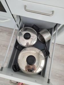 two pots and pans are sitting in a shelf at TapiolaSky: airy, bright, great bed and spacious - close to Aalto campus and Tapiola center in Espoo