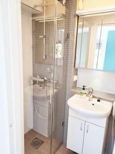a bathroom with a shower and a sink and a toilet at TapiolaSky: airy, bright, great bed and spacious - close to Aalto campus and Tapiola center in Espoo
