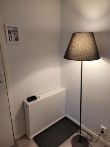 a room with a lamp and a small refrigerator at TapiolaSky: airy, bright, great bed and spacious - close to Aalto campus and Tapiola center in Espoo