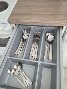 a drawer with silver utensils in a cabinet at TapiolaSky: airy, bright, great bed and spacious - close to Aalto campus and Tapiola center in Espoo