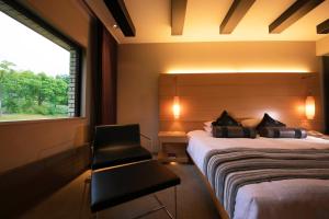 a bedroom with a bed and a chair and a window at Niseko Northern Resort, An'nupuri in Niseko