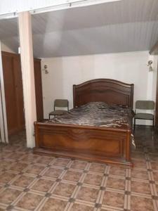 - une chambre avec un lit en bois et des chaises dans l'établissement Cozy apartment in the heart of Yerevan, à Erevan